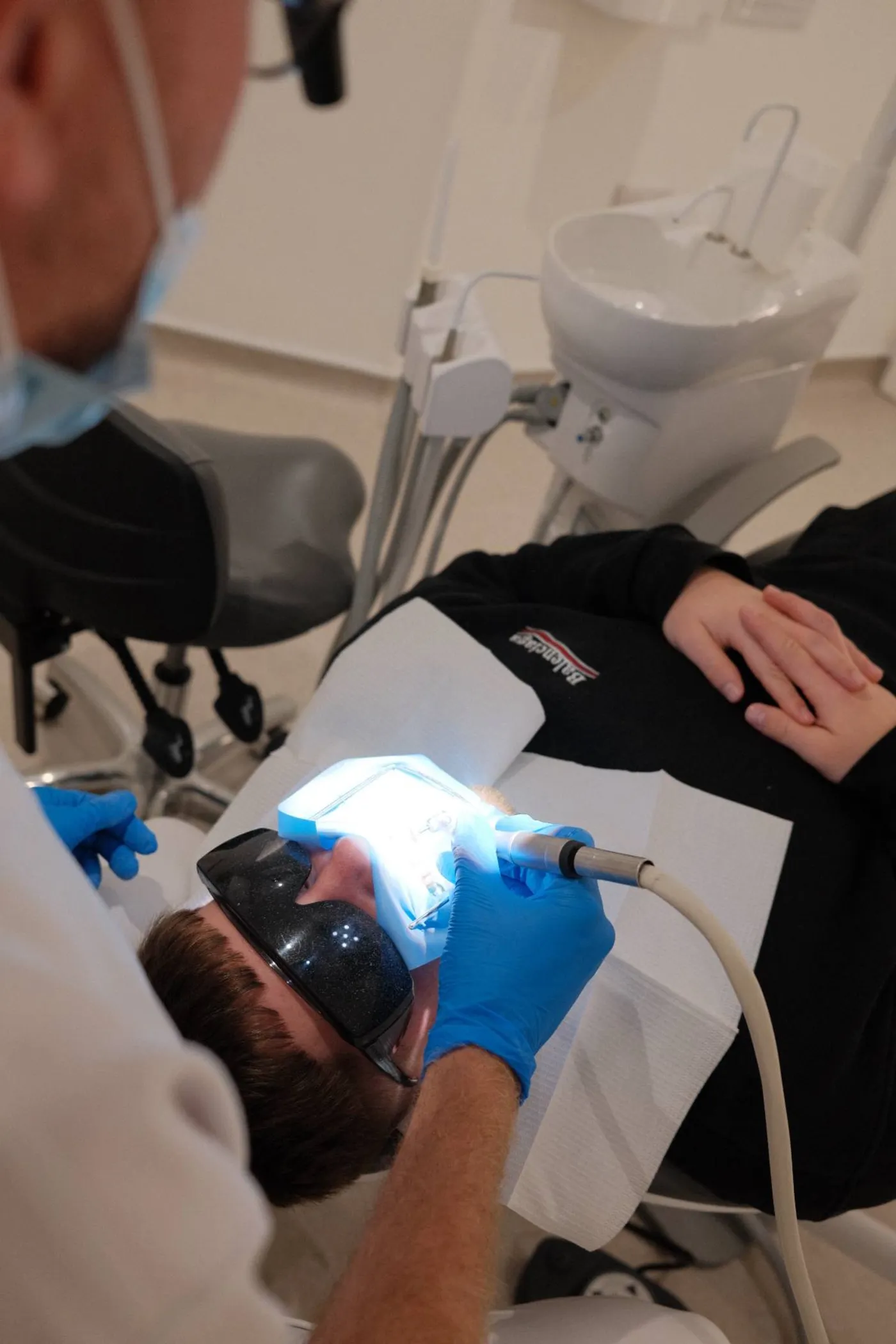 Over-the-shoulder view of curing light and intraoral mirror during treatment